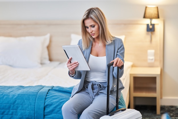 Adult businesswoman working on computer in hotel room