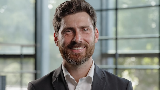 Adult calm strong confident caucasian s bearded man looking at camera with serious expression