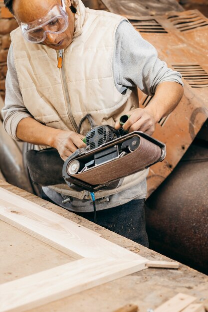 Foto carpentiere adulto che lavora nella sua officina