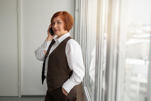 adult caucasian businesswoman in a suit calls on the phone in the office