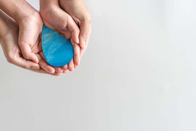 Adult and child hands holding the water drop on their hand