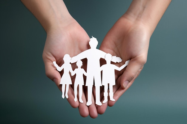 Adult and children hands holding paper family cutout ar c