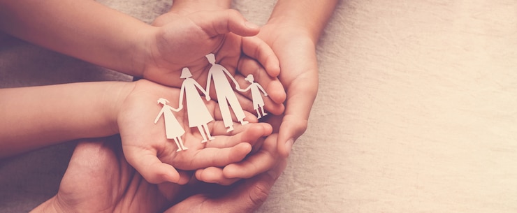 Photo adult and children hands holding paper family cutout, family home, foster care, homeless support 
