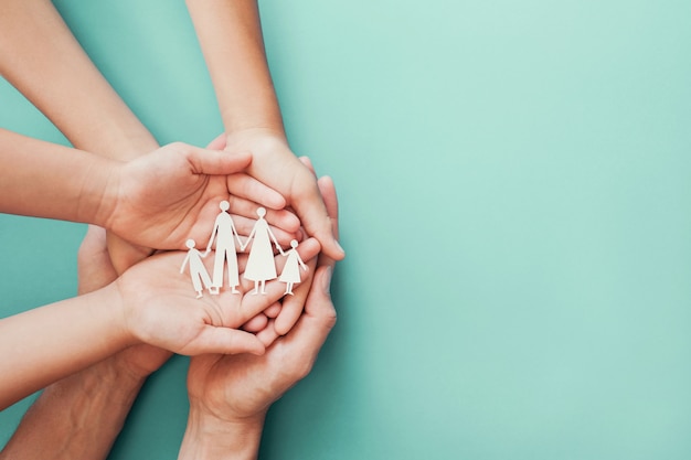 Photo adult and children hands holding paper family cutout