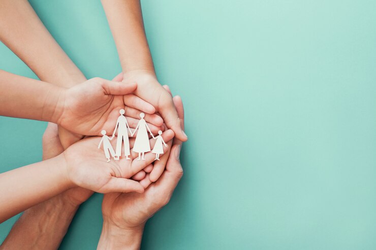 Adult and children hands holding paper family cutout