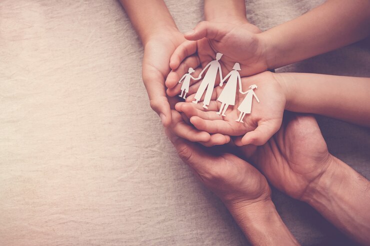 Photo adult and children hands holding paper family cutout