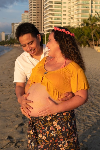 Взрослая пара ждет ребенка, пока муж ласкает живот своей беременной латинской жены Прекрасный латиноамериканец трогает живот своей подруги и чувствует движение ребенка