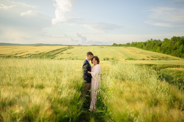 Photo adult couple in a green wheat field.