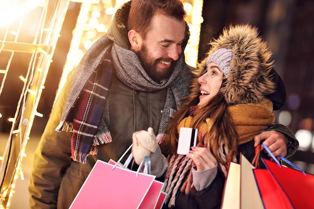 クリスマスの時期に街で買い物をする大人のカップル