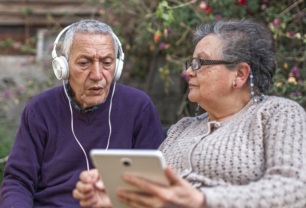 adult couple using a laptop a park