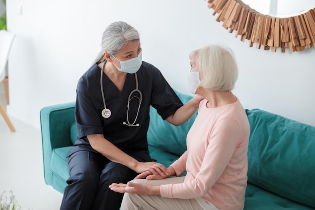 Photo adult doctor speaking to elderly woman opposite