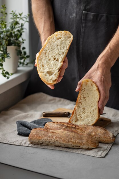 An adult european male baker holds a round fresh bread in his hands a man in a bakery holds a