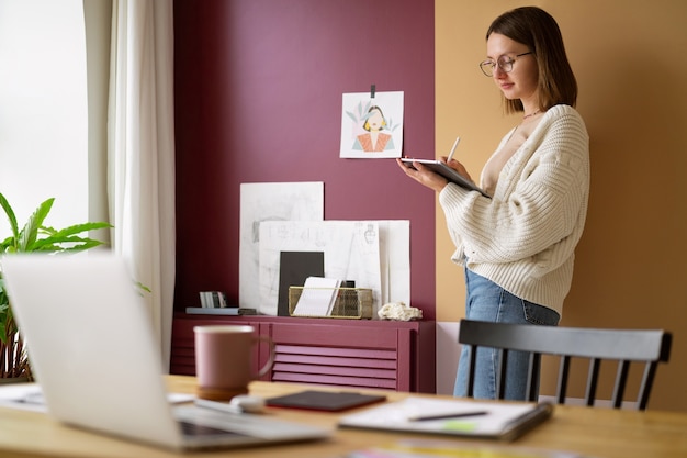 Foto illustratore femminile adulto che lavora su un dispositivo tablet