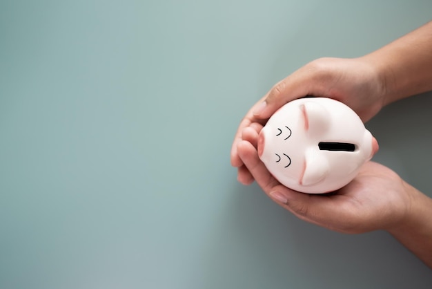 Photo adult hands holding a piggy bank in savings concept