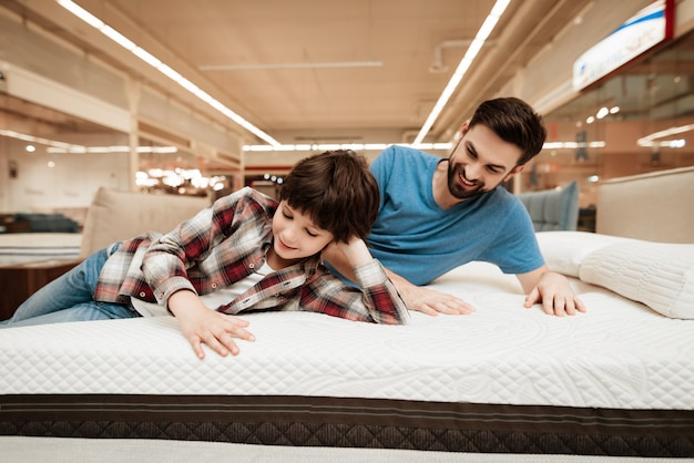 Photo adult handsome man and little boy on mattress