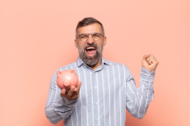 Adult handsome man looking extremely happy and surprised, celebrating success, shouting and jumping