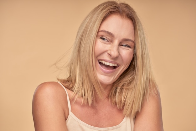 Adult lady in shirt looking away and smiling in studio