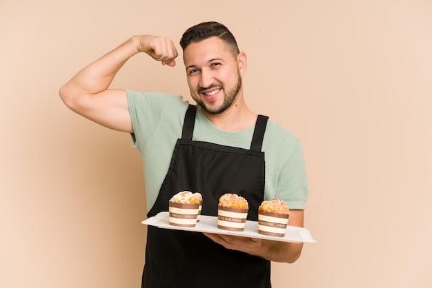 マフィン トレイを保持している大人のラテン料理男カットアウト分離