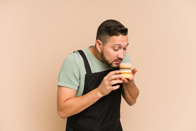 Adult latin cook man holding a muffins tray cut out isolated