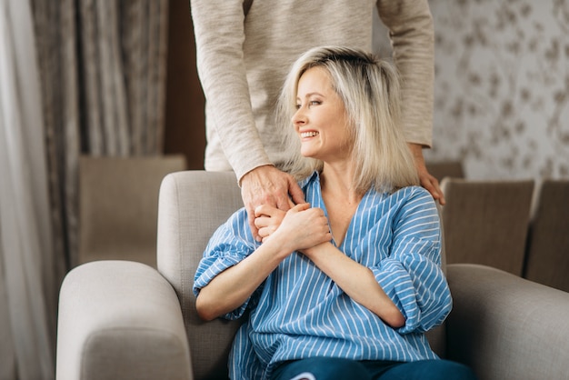 Adult love couple, man hugs woman at home