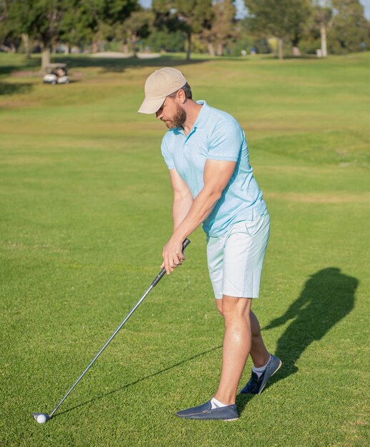 Giocatore di golf maschio adulto sul corso professionale con il giocatore di golf dell'erba verde