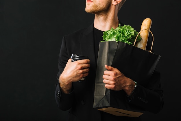 Adult male holding groceries bag