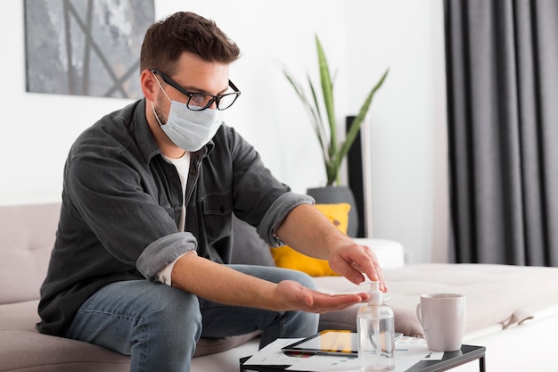 Adult male using hand sanitizer at home