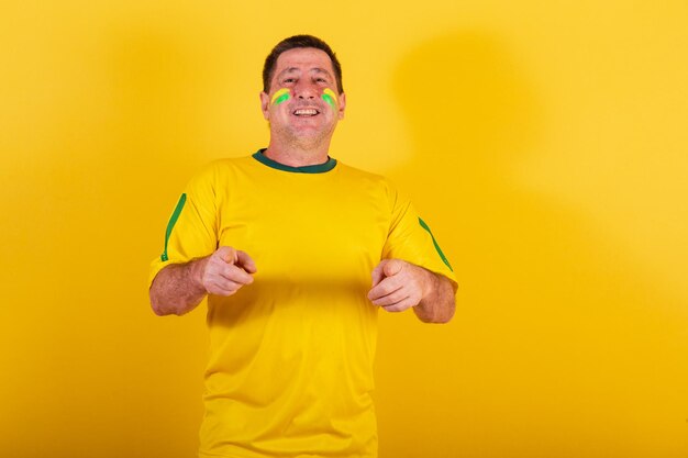 Adult man brazil soccer fan pointing at camera choosing you advertising photo