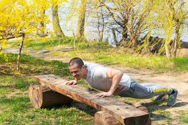 写真 腕立て伏せをしている大人の男性は暖かい春の日に屋外で運動します