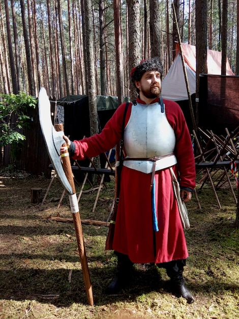 Photo adult man dressed in historical costume with poleaxe