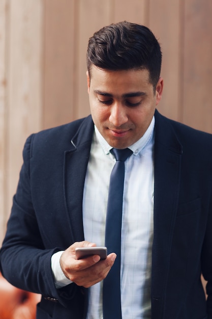 スマートフォンを手に持っている大人の男性。