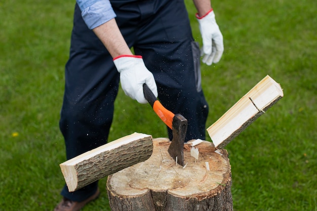 Adult man is chopping wood with axe