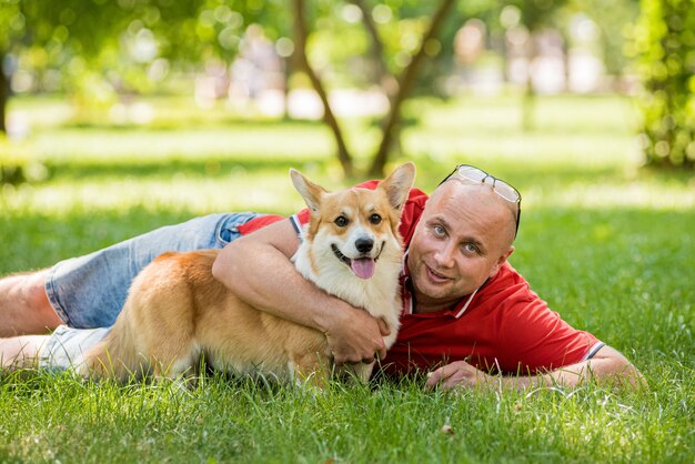 Adult man is training her welsh corgi pembroke dog at city park