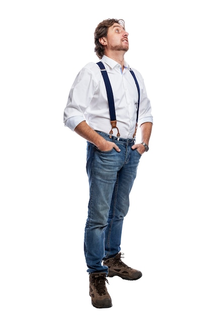 An adult man in jeans and a white shirt stands and looks up. Full height. Attention and focus. Isolated on white background. Vertical.