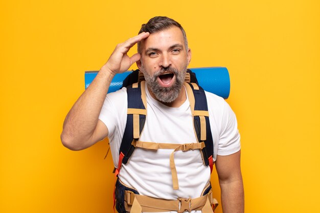 Adult man looking happy, astonished and surprised, smiling and realizing amazing and incredible good news