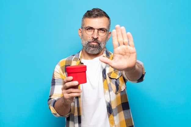 Adult man looking serious, holding a gift box