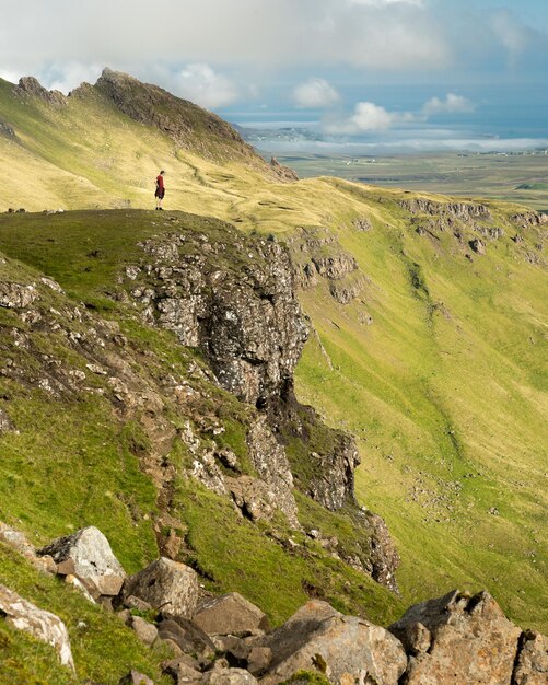 Adult man looking at the storr - rock formations in trotternish landslip isle of skye scotland