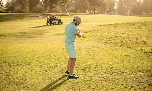 緑の草のスポーツマンでゴルフゲームをしている大人の男