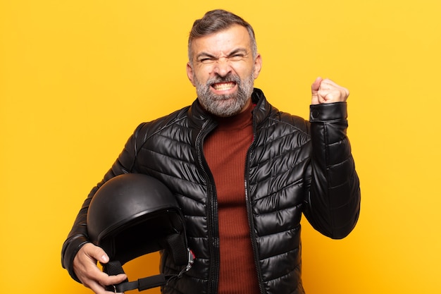 Photo adult man shouting aggressively with an angry expression or with fists clenched celebrating success