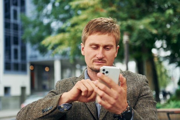 Adult man sitting outdoors at the cafe table at daytime