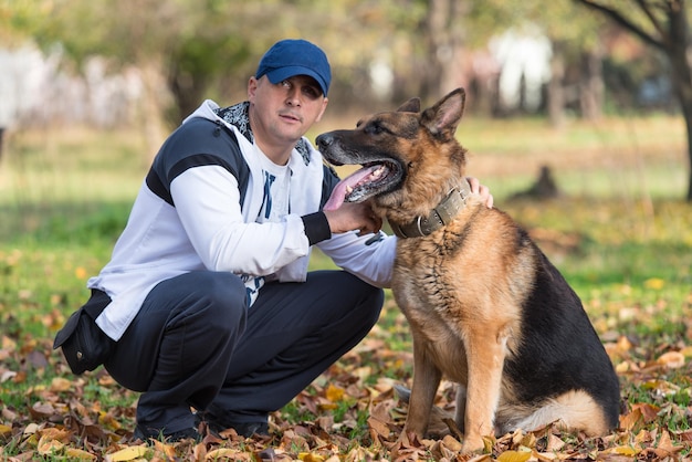 Adult Man Sitting Outdoors With His German Shepherd