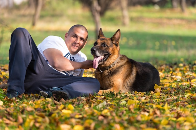 Adult Man Sitting Outdoors With His German Shepherd