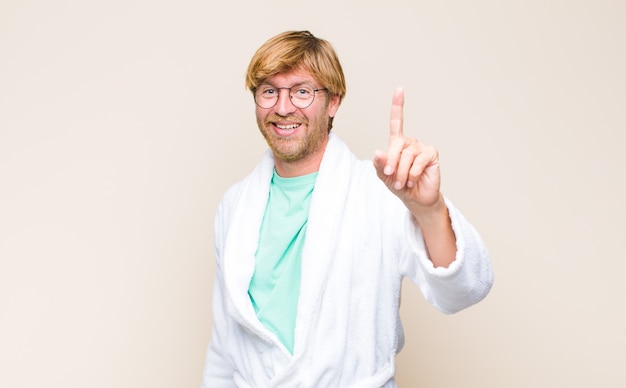 Adult man wearing a bathrobe and glasses