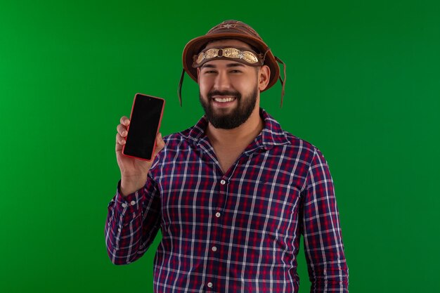 Uomo adulto con la barba che indossa una camicia a quadri e un cappello cangaceiro tipico della festa junina