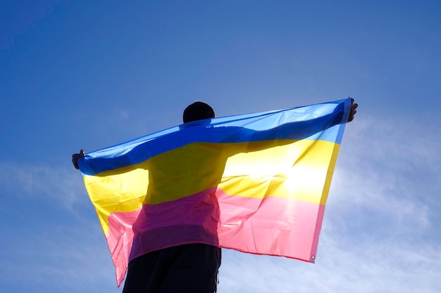 adult man with bisexual flag on a sunny day.