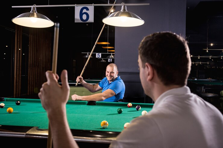 Photo adult men with disabilities in a wheelchair play billiards in the club