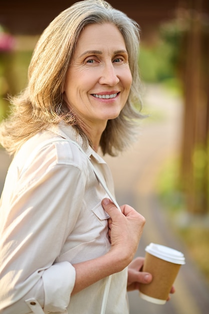 Photo adult optimistic woman with coffee outdoors