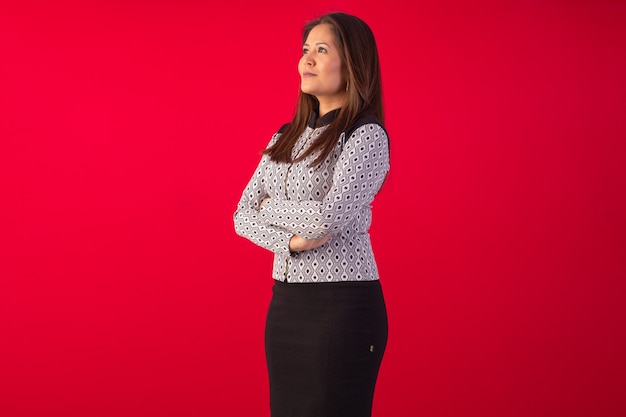 Adult oriental woman wearing formal wear in studio photo with blue background.