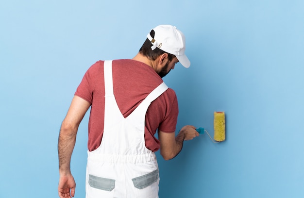 Adult painter man over isolated blue wall
