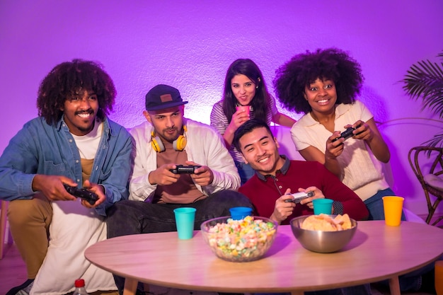 Photo adult party attractive young men sitting on the sofa playing video games expressing joy while holding the joystick and looking at the monitor